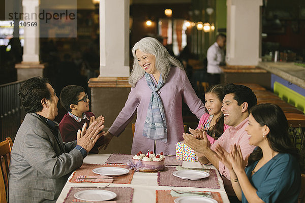 Familie feiert den Geburtstag einer älteren Frau in einem Restaurant