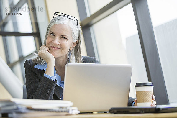 Porträt einer lächelnden kaukasischen Geschäftsfrau mit Laptop