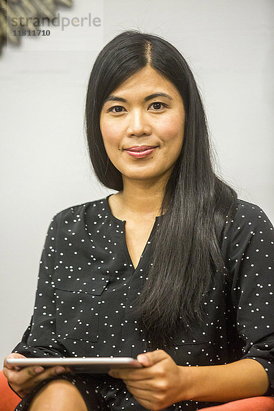 Porträt einer asiatischen Frau mit digitalem Tablet