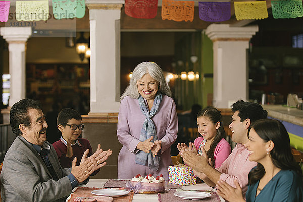 Familie feiert den Geburtstag einer älteren Frau in einem Restaurant