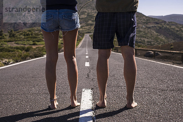 Beine eines barfuß lebenden kaukasischen Paares mitten auf der Straße