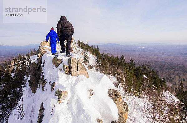 Kaukasische Männer beim Wandern auf einem Berg im Winter