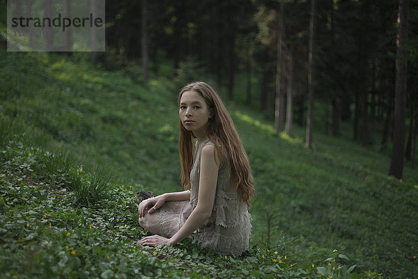 Ernste kaukasische Frau sitzt auf einem Hügel