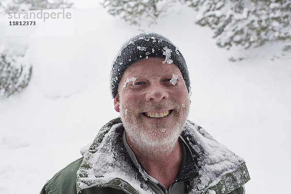 Kaukasischer Mann mit Eis und Schnee bedeckt