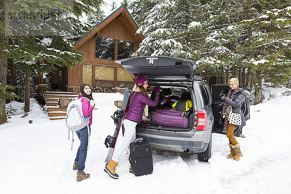 Freunde entladen Auto im Wintersportort