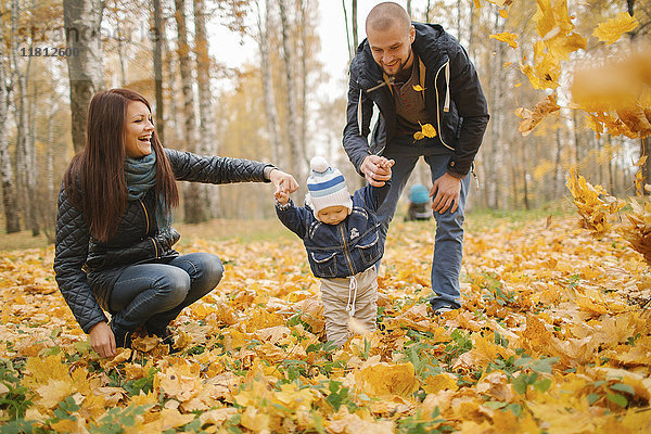 Eltern aus dem Nahen Osten gehen mit ihrem kleinen Sohn im Herbst spazieren