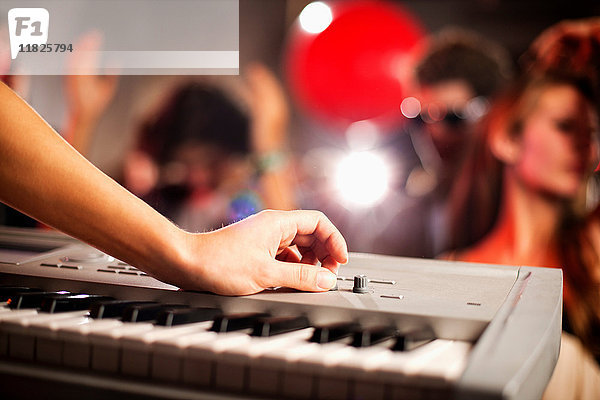 Junge Frau spielt Keyboard in einem Nachtclub