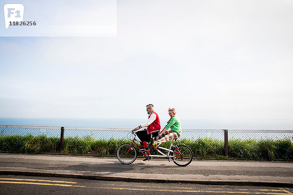 Schrulliges Paar beim Sightseeing auf dem Tandemfahrrad  Bournemouth  England