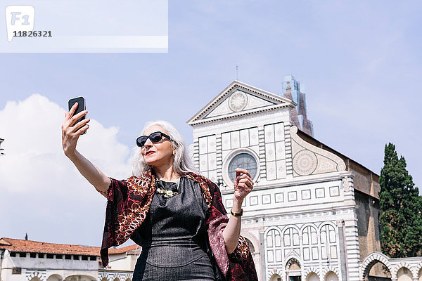 Stilvolle  reife Frau nimmt Selbstliebe vor der Kirche Santa Maria Novella  Florenz  Italien