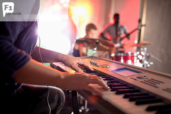 Frau spielt Keyboard  Band im Hintergrund