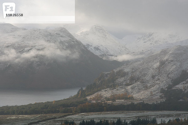 Niedrige Wolken und schneebedeckte Berge bei Ullswater  Lake District  Großbritannien