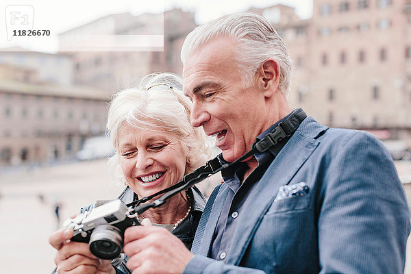 Touristenpaar bespricht Digitalkamera auf dem Stadtplatz  Siena  Toskana  Italien