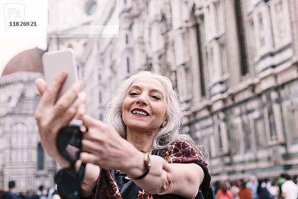 Stilvolle  reife Frau nimmt Smartphone-Selfie in Florenz  Italien