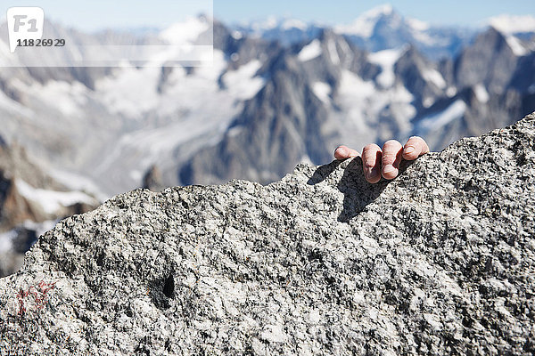 Die Hand des Bergsteigers auf dem Gipfel  Nahaufnahme