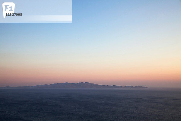 Seelandschaft und Fernsicht auf die Insel Andros von der Insel Tinos bei Sonnenuntergang  Griechenland