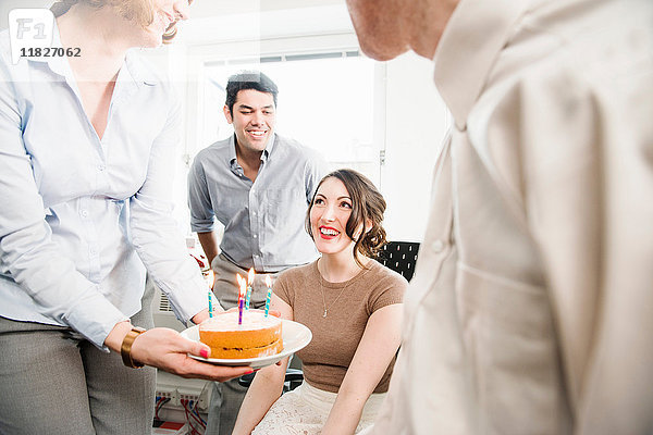 Weibliche Büroangestellte erhält Geburtstagskuchen