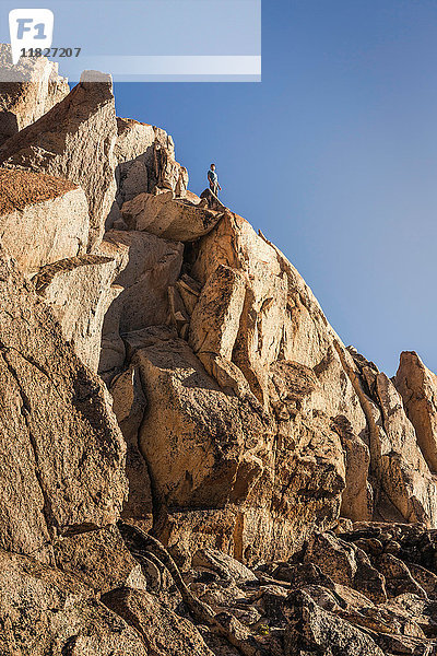 Männlicher Bergsteiger mit Blick von der Spitze einer zerklüfteten Felswand  Anden  Nahuel-Huapi-Nationalpark  Rio Negro  Argentinien