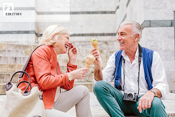 Touristenpaar beim Essen von Eiswaffeln und Lachen in Siena  Toskana  Italien
