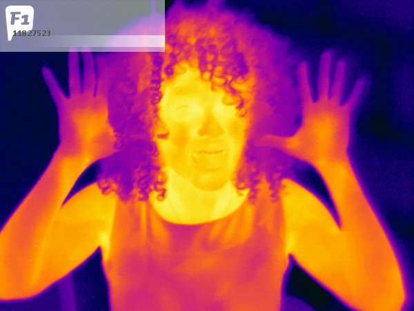 Wärmebildporträt einer mittleren erwachsenen Frau mit erhobenen Händen