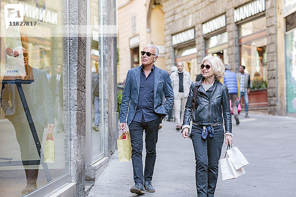 Touristenpaar schlendert mit Einkaufstaschen auf der Straße in der Stadt  Siena  Toskana  Italien