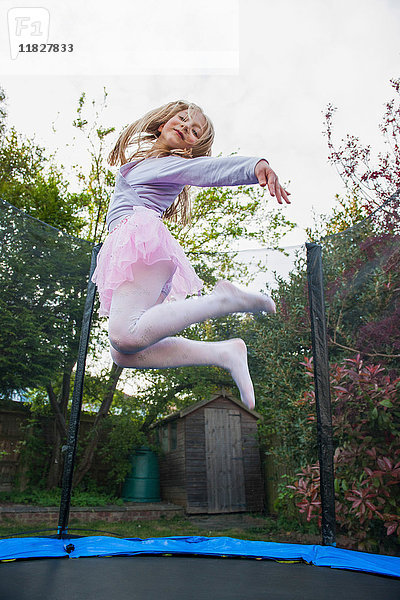 Mädchen hüpft auf dem Trampolin und trägt Tutu