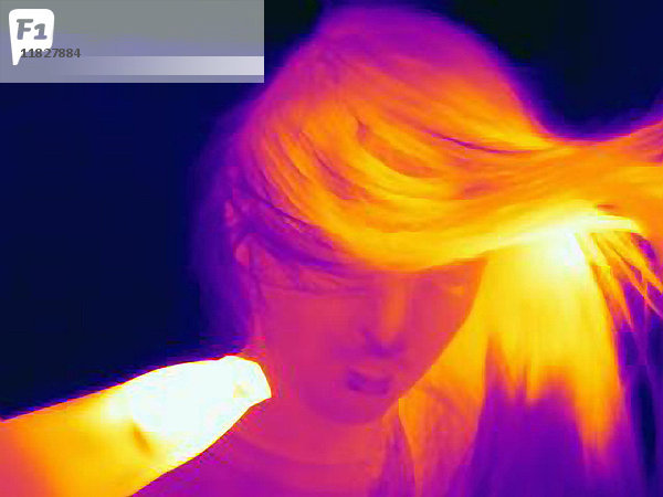 Wärmebild einer jungen Frau  die ihr Haar trocknet