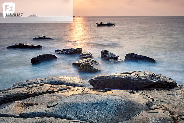 Küstenfelsen und Boot bei Sonnenaufgang  Dazuo  Fujian  China