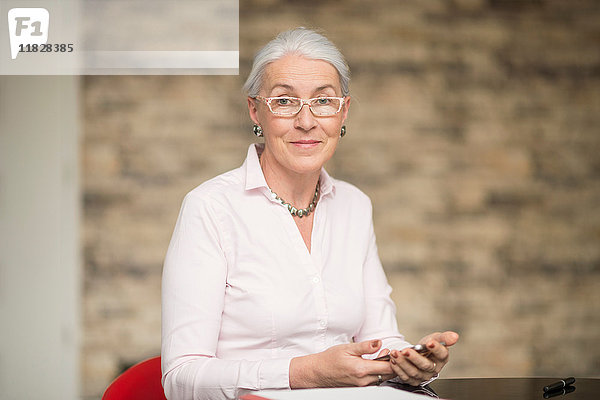 Porträt einer reifen Geschäftsfrau am Büroschreibtisch