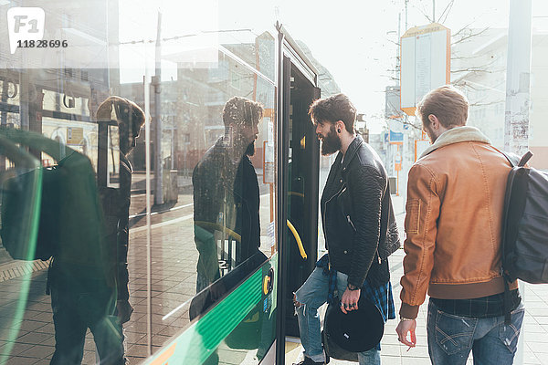 Zwei junge Männer steigen an der Stadtbahnhaltestelle in die Straßenbahn