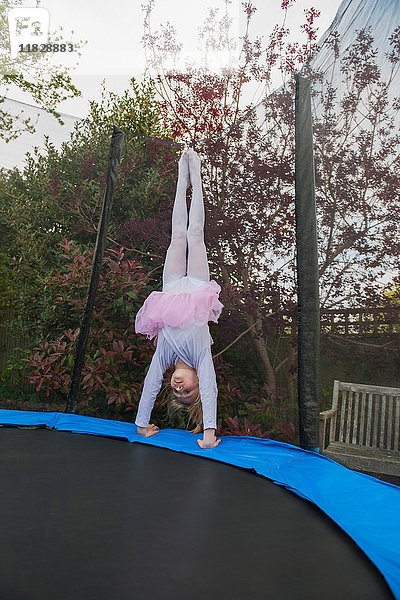 Mädchen auf Trampolin mit Tutu beim Handstand