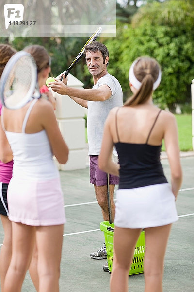 Tennistrainer demonstriert für Studenten