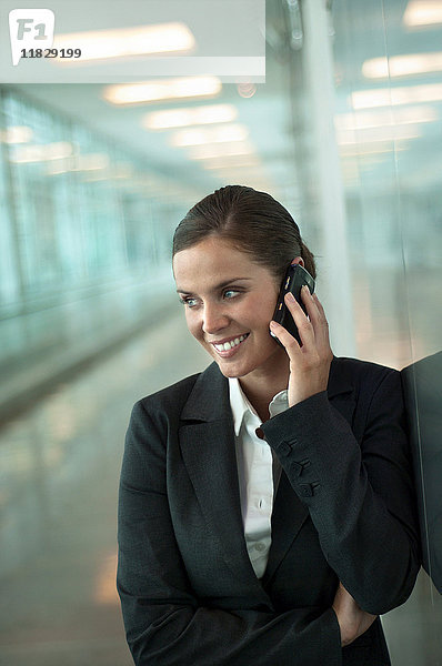 Frau am Telefon auf einem Flughafen