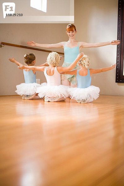 Mädchen posieren im Ballettunterricht