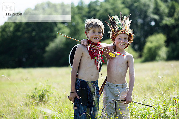 Kinder in Kostümen umarmen sich auf dem Feld