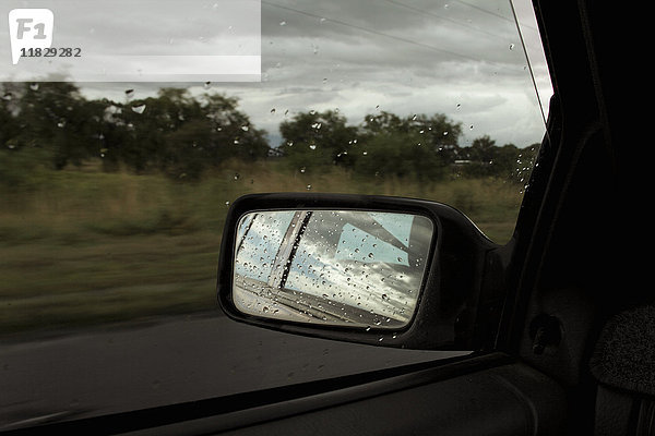 Regentropfen auf dem Seitenspiegel eines Autos
