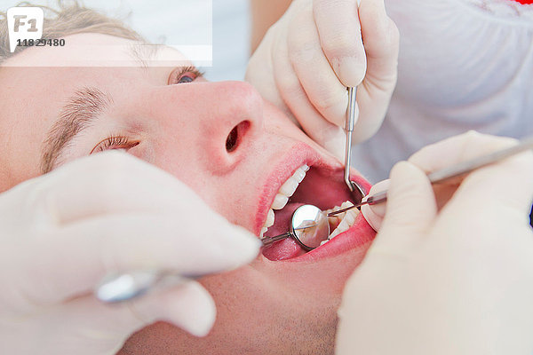 Zahnärzte  die an den Zähnen von Patienten arbeiten