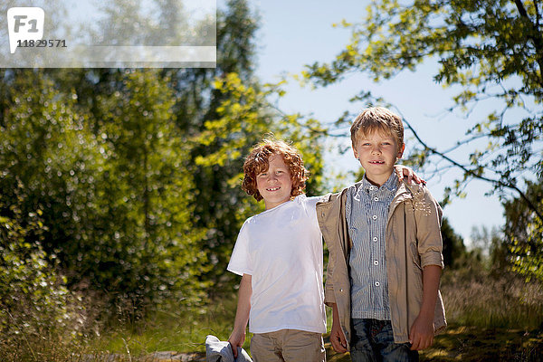 Lächelnde Kinder  die sich im Freien umarmen