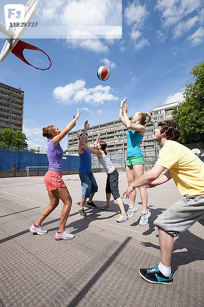 Freunde spielen gemeinsam Basketball