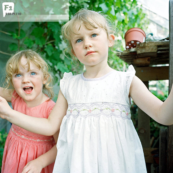 Zwei kleine Mädchen in einem Gewächshaus