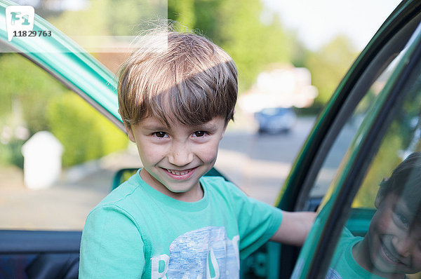 Lächelnder Junge neben dem Auto