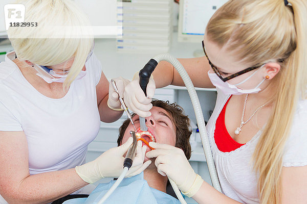 Zahnärzte  die an den Zähnen von Patienten arbeiten