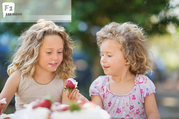 Mädchen essen Erdbeeren im Freien