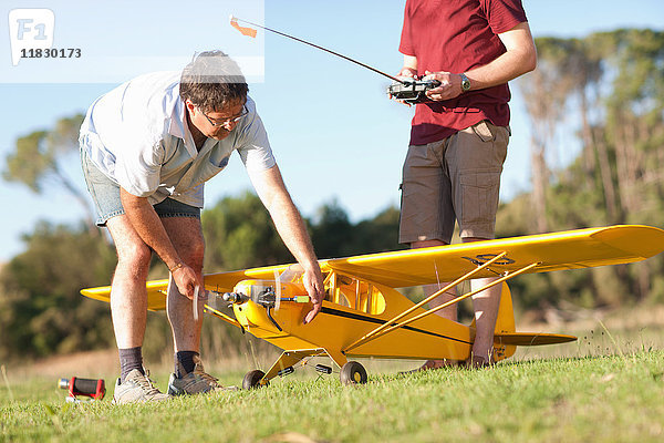 Männer spielen mit Spielzeugflugzeug im Park