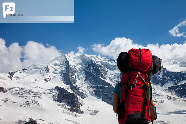 Rucksacktourist bewundert verschneite Berge