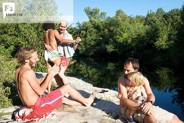 Familie entspannt in Badeanzügen am Fluss
