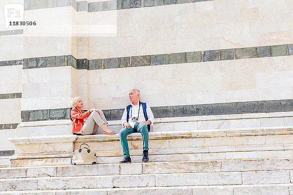 Touristenpaar sitzt auf der Treppe der Kathedrale von Siena  Toskana  Italien