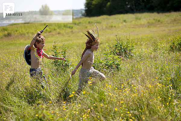 Kinder in Kostümen laufen im Feld