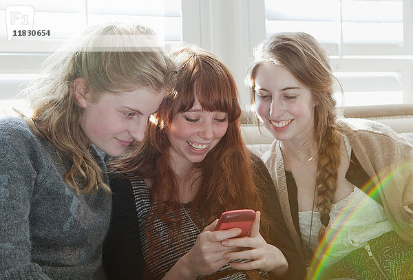Mädchen im Teenageralter telefonieren auf der Couch
