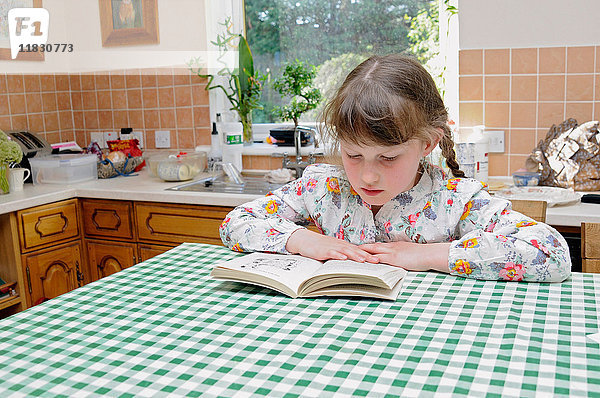 Mädchen liest am Küchentisch