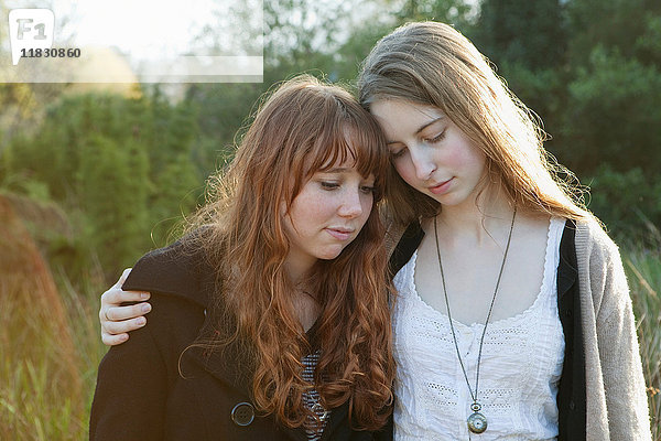 Mädchen im Teenageralter umarmen sich im Freien